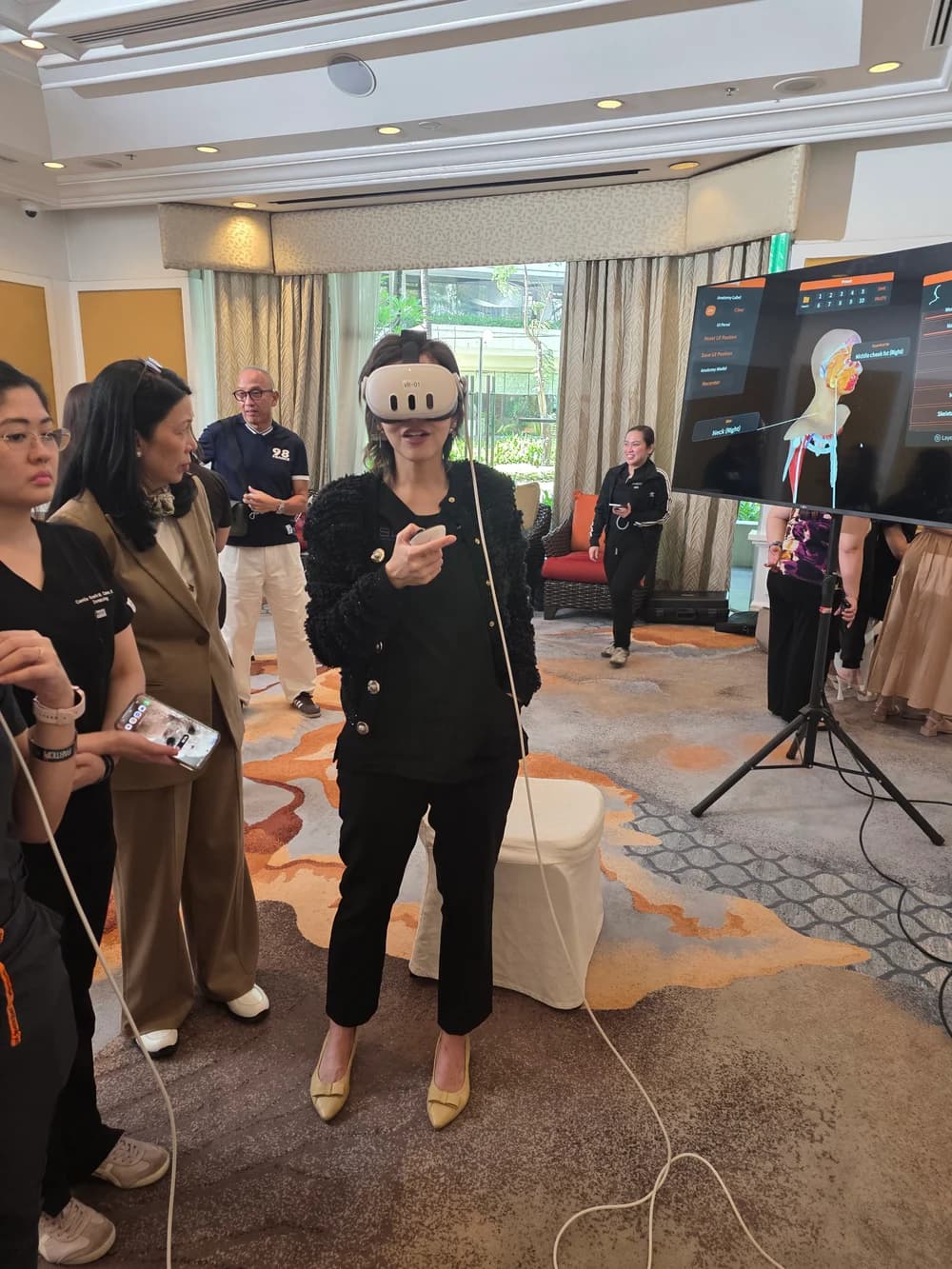 A participant exploring FAesthetics VR during an educational workshop, with the anatomy view displayed on a monitor